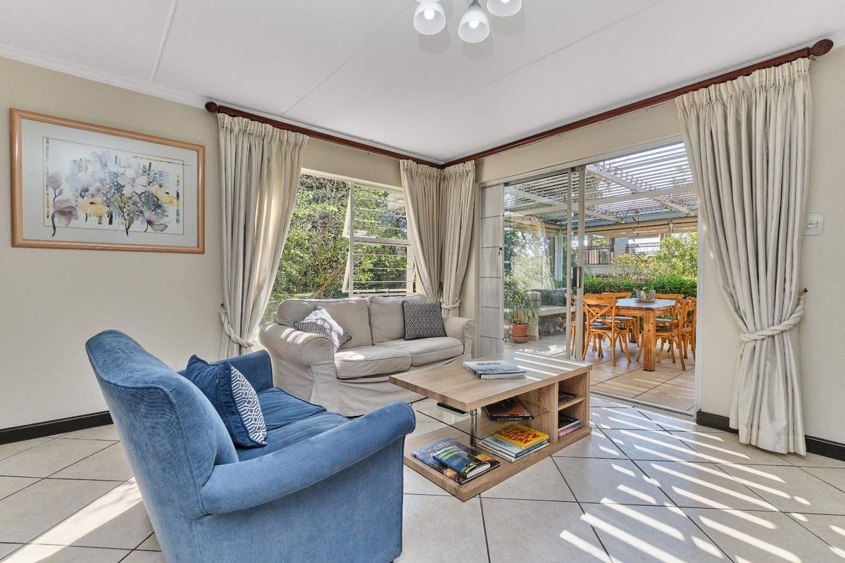 Bright living room featuring tiled flooring and large sliding glass doors that provide seamless access to the outdoor patio area.