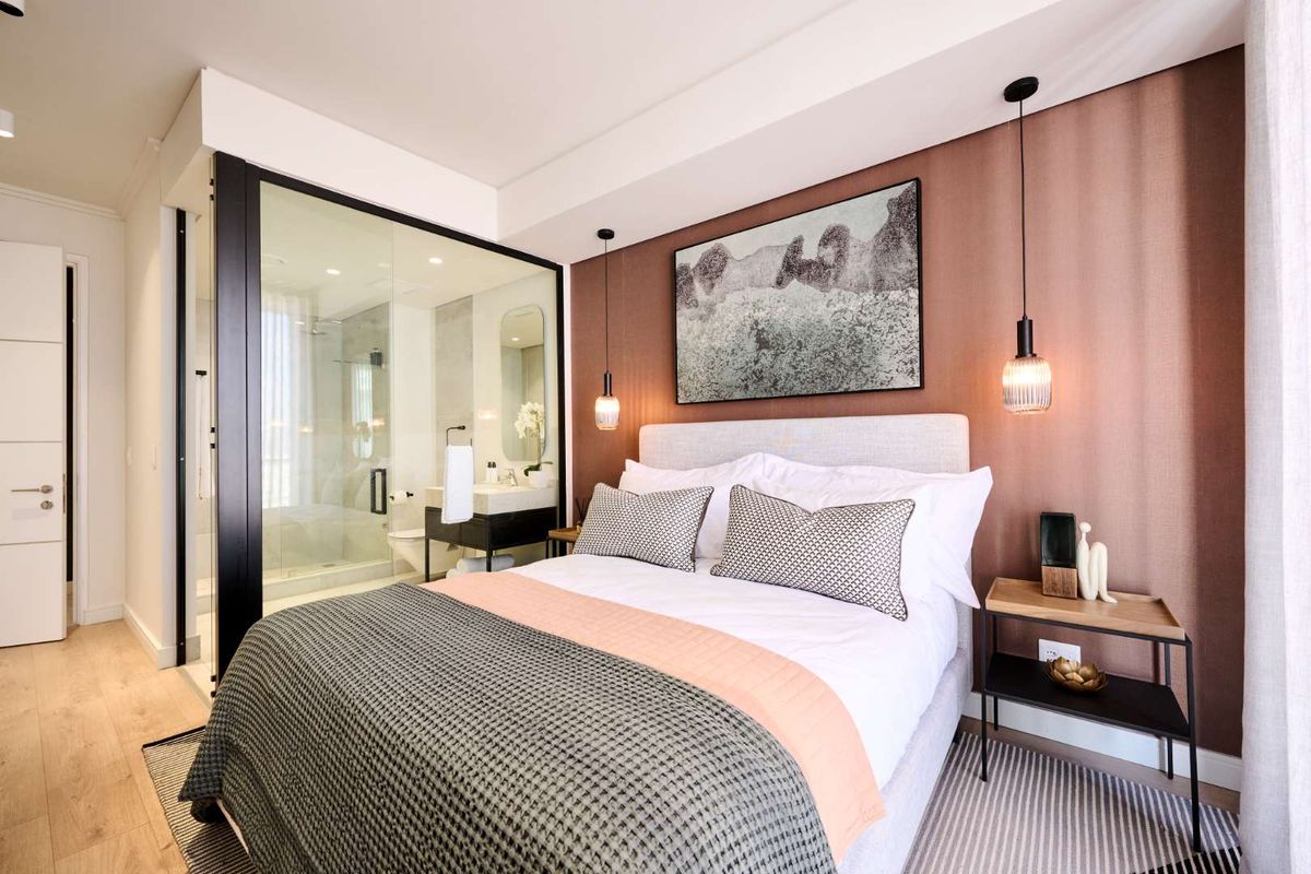 Modern bedroom featuring a glass-enclosed en-suite bathroom, accent wall, and contemporary pendant lighting in a high-end penthouse setting.