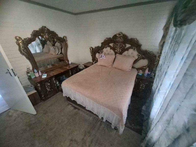 A bedroom featuring carpet flooring and painted brick walls, offering a blank canvas for potential modernization and interior updates.