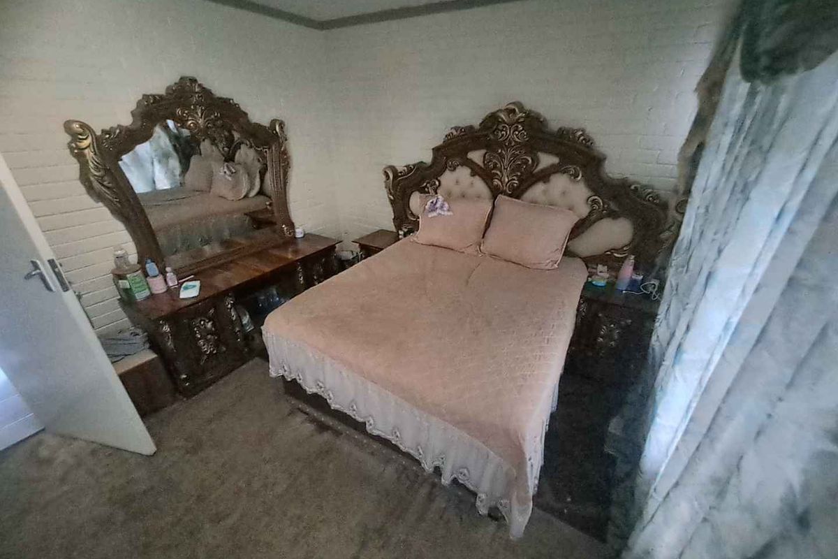 A bedroom featuring carpet flooring and painted brick walls, offering a blank canvas for potential modernization and interior updates.