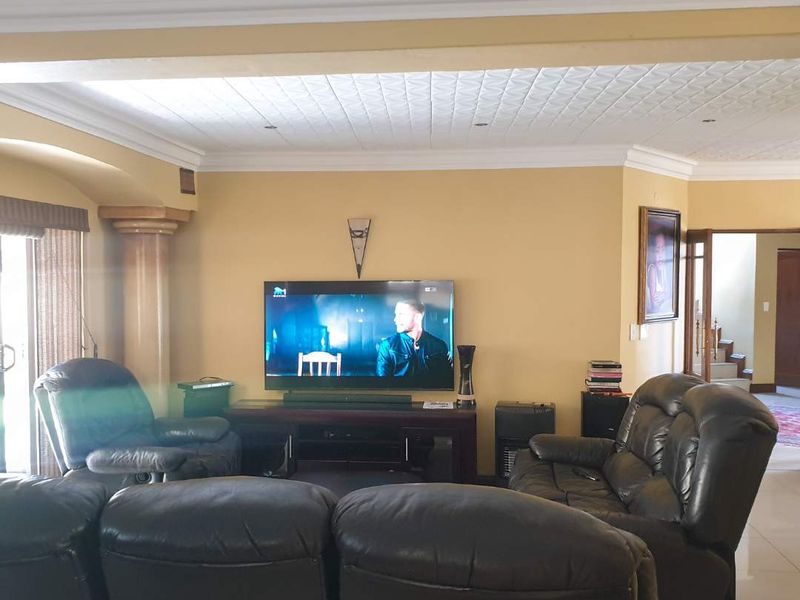 A living room featuring decorative ceiling tiles, crown molding, and a sliding glass door leading to an outdoor area.