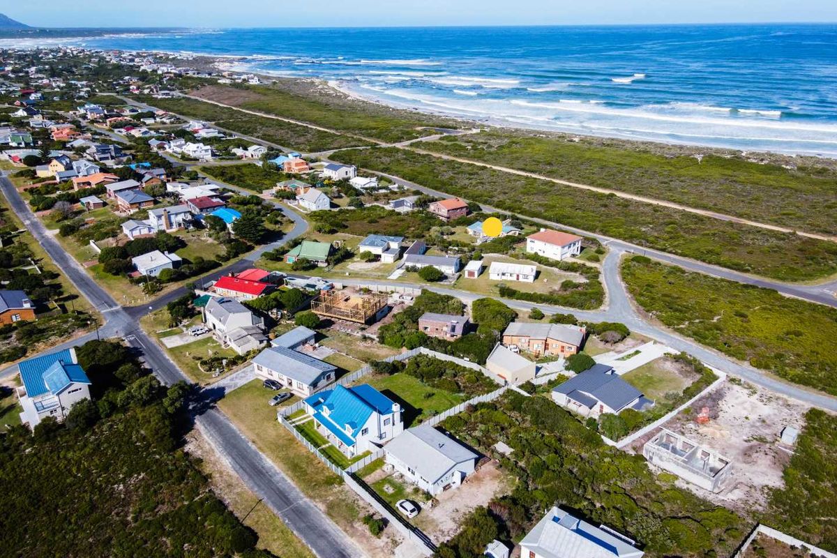 An aerial view of a coastal residential neighbourhood, highlighting the property's proximity to the beach and surrounding landscape.