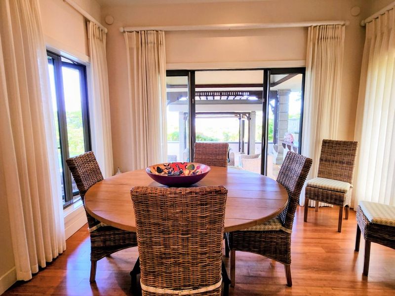 A bright dining room featuring hardwood flooring and large sliding glass doors that provide seamless access to the outdoor patio area.