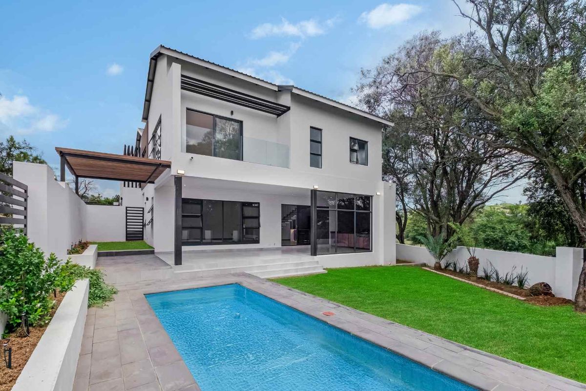 Modern double-story residence featuring a swimming pool, landscaped garden, covered patio, and large glass sliding doors for seamless indoor-outdoor living.