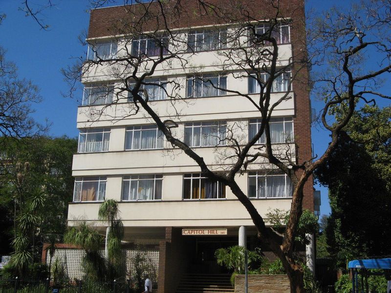 Front elevation of Capitol Hill apartment building featuring a multi-story facade with brick accents, metal-framed windows, and a covered ground-level entrance.