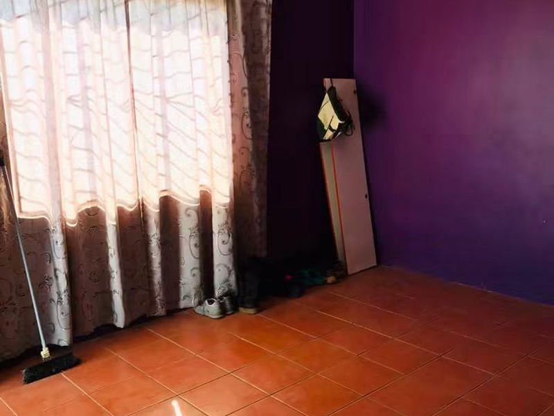 A vacant bedroom featuring tiled flooring and purple painted walls, offering a blank canvas for renovation or restyling.