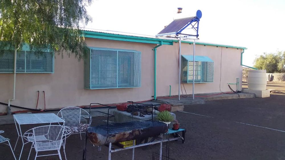 Main house- back yard view of the house with outside seating area and a tree for shade. Also a great spot for an outside BBQ