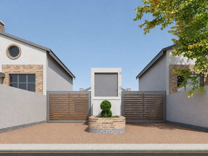 Front elevation of a modern townhouse complex featuring a paved driveway, secure gated entrance, and contemporary architectural brick and plaster finishes.