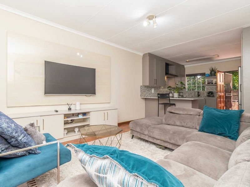 Open-plan living area featuring a modern kitchen with built-in cabinetry, a breakfast island, and seamless flow into the comfortable lounge space.