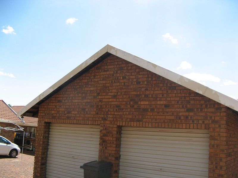 Exterior view of a double garage featuring face brick construction and painted barge boards.