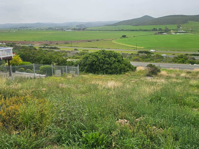 Expansive rural landscape view overlooking green fields and distant hills from an elevated residential vantage point.