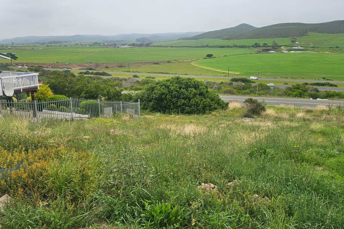 Expansive rural landscape view overlooking green fields and distant hills from an elevated residential vantage point.