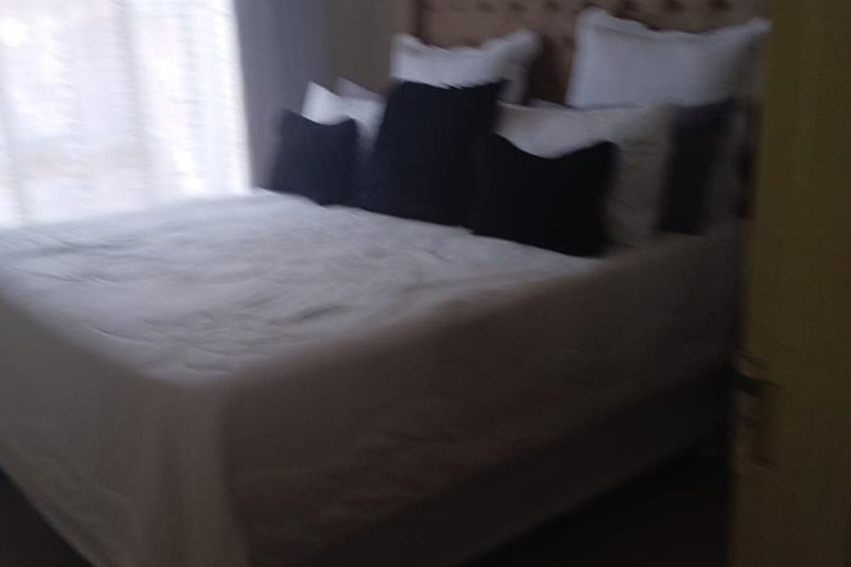 A bedroom featuring tiled flooring and a window with natural light.