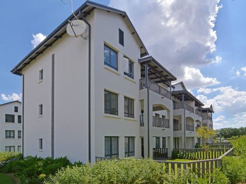 A well-maintained multi-story apartment complex featuring modern architectural design, private balconies, and landscaped garden surrounds.