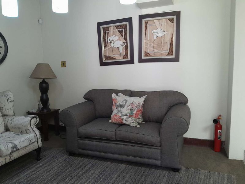 A functional waiting or reception area featuring neutral walls, pendant lighting, and a wall-mounted fire extinguisher.