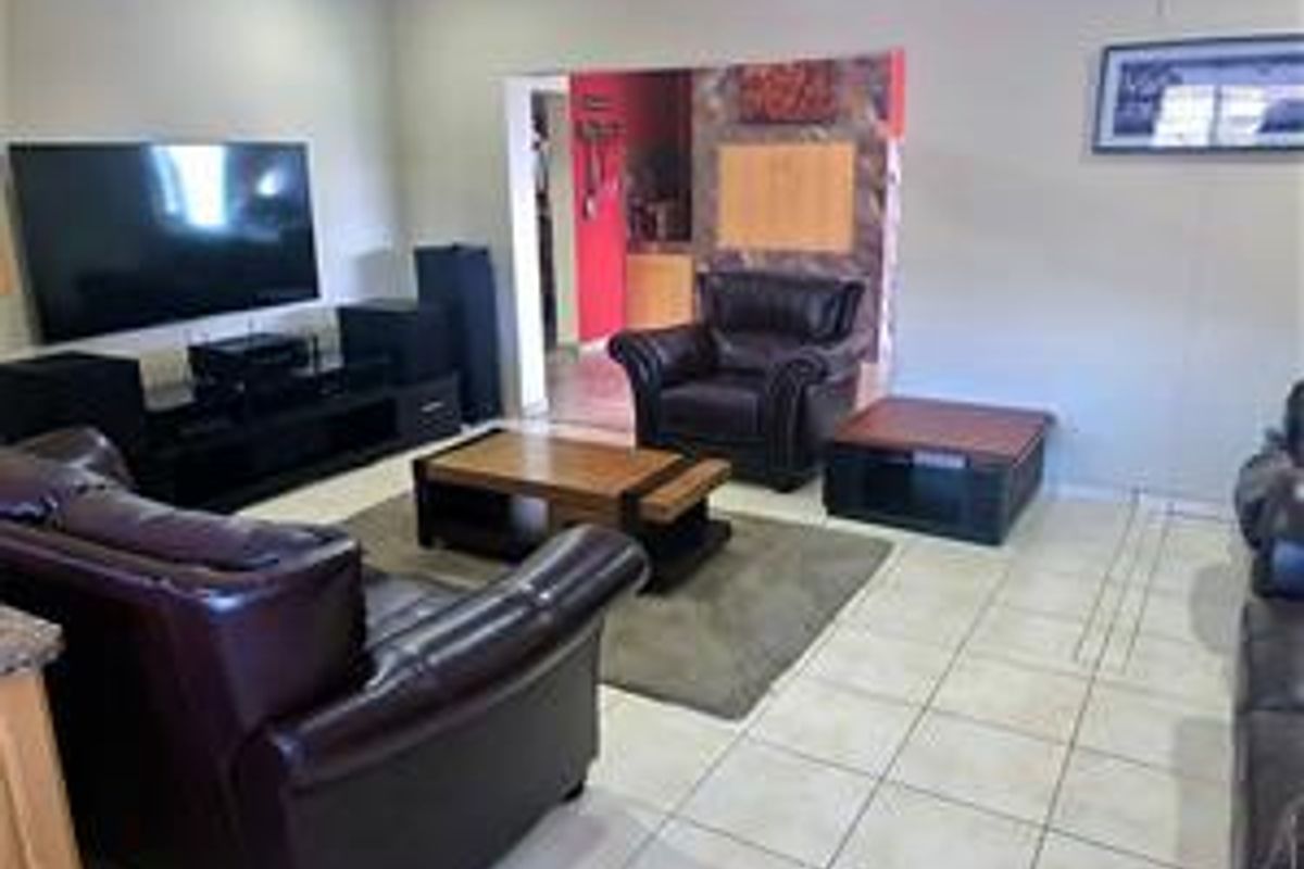 Spacious living room featuring neutral wall tones and tiled flooring, providing a comfortable area for relaxation and entertainment.