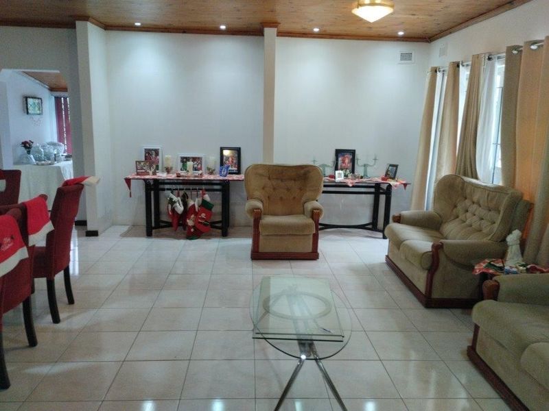 Spacious living area featuring light-colored floor tiles and a warm timber-paneled ceiling, providing a neutral foundation for interior updates.