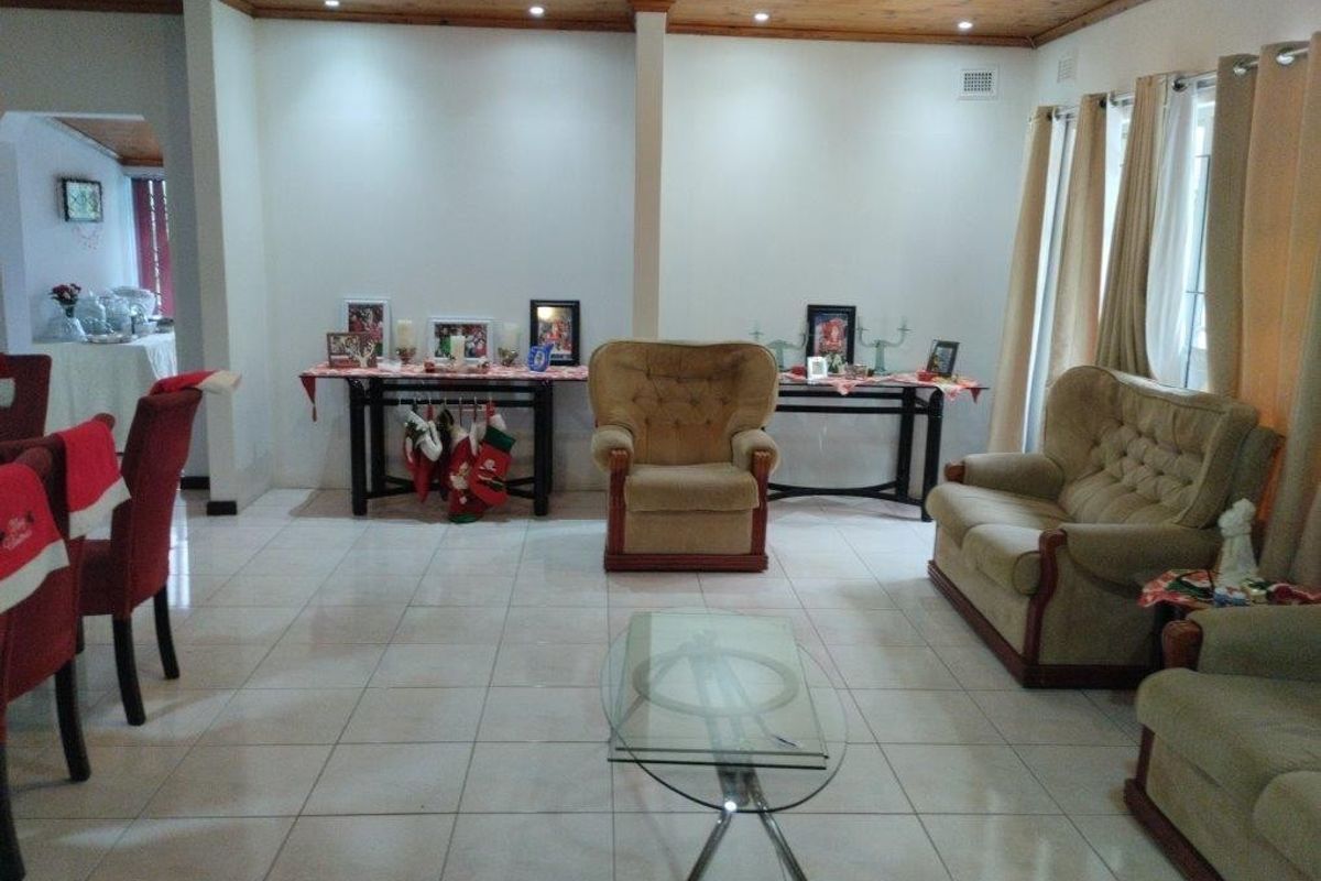 Spacious living area featuring light-colored floor tiles and a warm timber-paneled ceiling, providing a neutral foundation for interior updates.