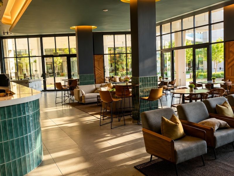 Spacious open-plan lounge and bar area featuring modern ceramic tiling, floor-to-ceiling windows, and high-quality architectural finishes throughout.
