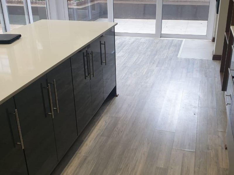 Modern kitchen featuring a central island with quartz countertops, dark cabinetry, gas hob, and direct access to the outdoor patio area.