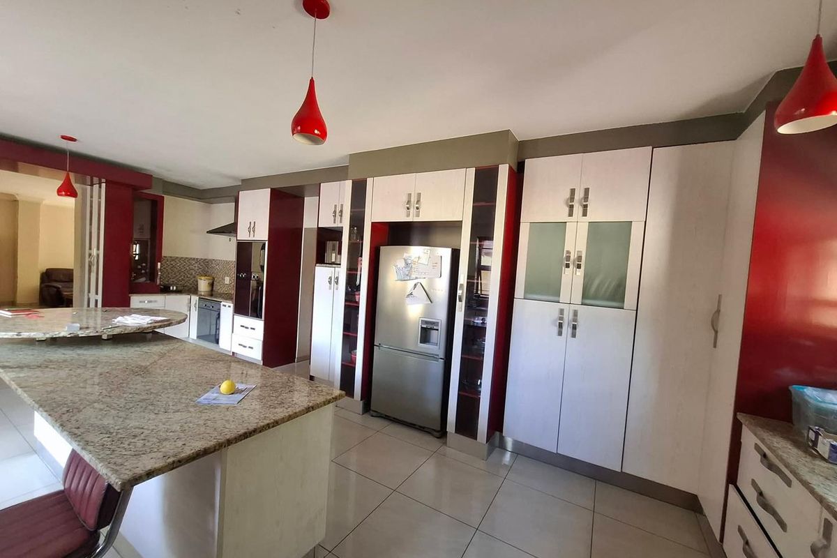 Spacious kitchen featuring granite countertops, extensive built-in cabinetry, and a central island, providing ample storage and workspace for culinary activities.
