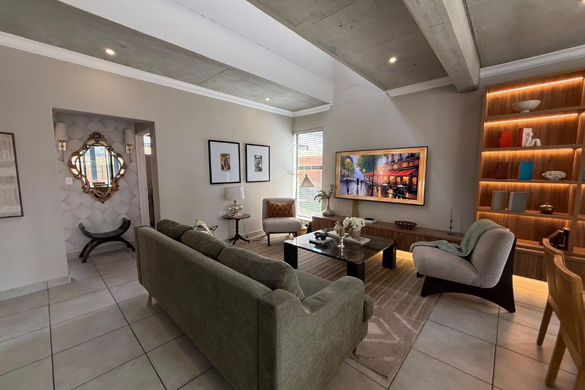 Modern living room featuring exposed concrete ceiling beams, tiled flooring, and a custom built-in wooden shelving unit with integrated ambient lighting.