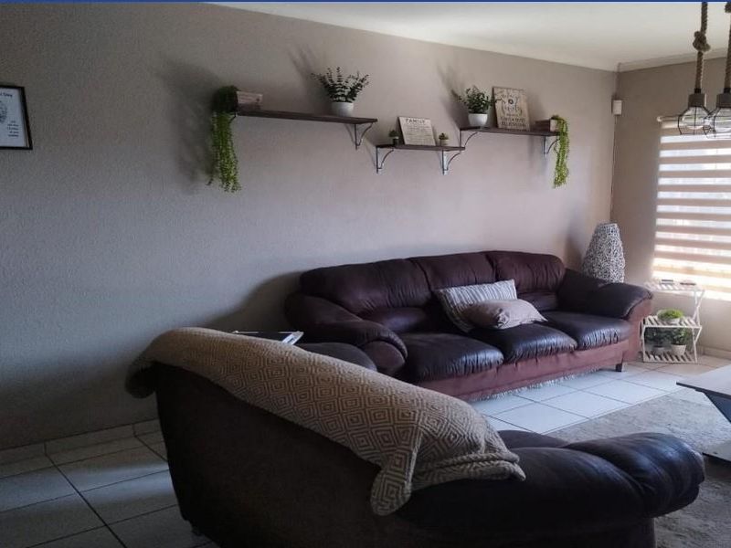 A comfortable living room featuring tiled flooring and modern roller blinds, providing a neutral foundation for your personal style.
