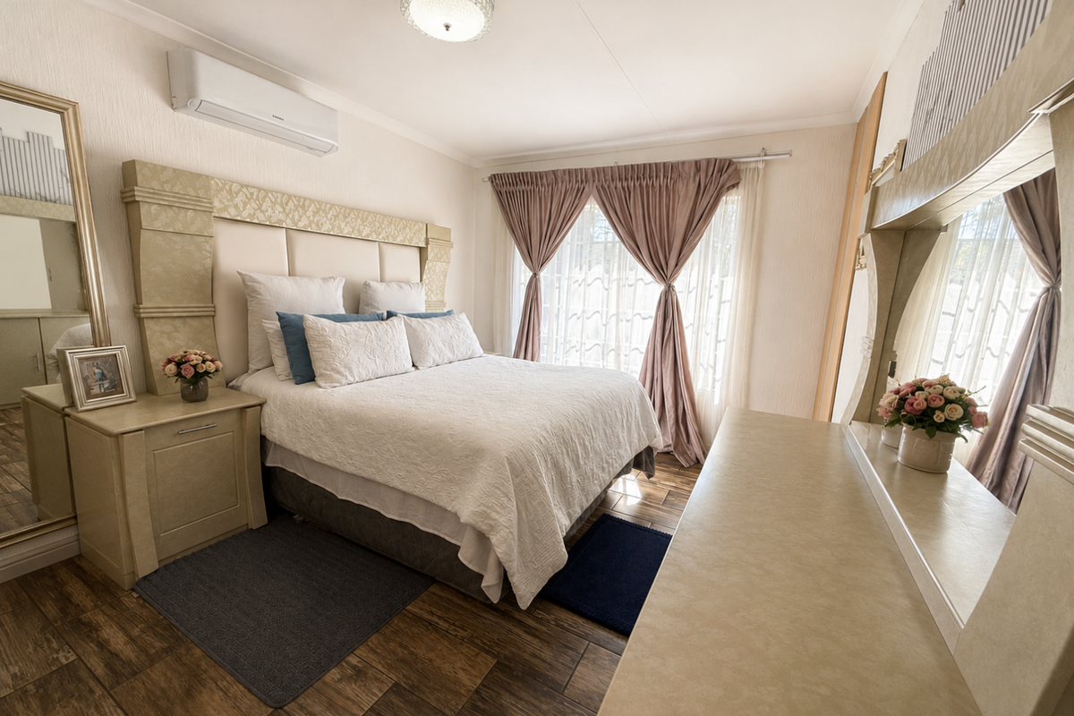 A well-maintained bedroom featuring wood-look tile flooring, a built-in headboard, and a wall-mounted air conditioning unit.