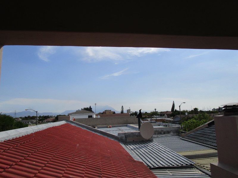 An elevated view overlooking the surrounding neighborhood rooftops and distant mountain landscape.
