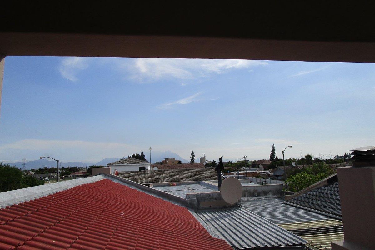 An elevated view overlooking the surrounding neighborhood rooftops and distant mountain landscape.