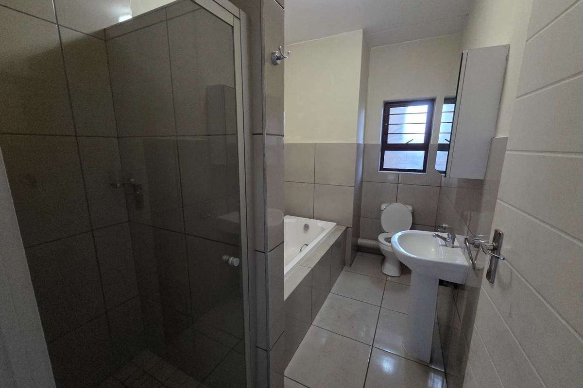 A clean, functional bathroom featuring a separate shower enclosure, built-in bathtub, pedestal basin, and toilet with neutral wall and floor tiling.