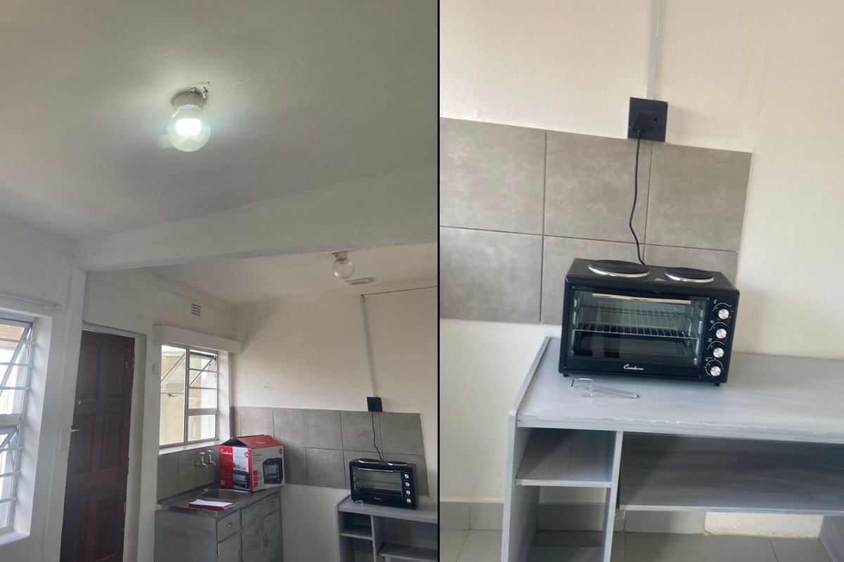A basic kitchen area featuring a stainless steel sink, tiled splashback, and casement windows, currently requiring cosmetic updates and electrical finishing.