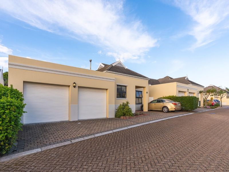 Front elevation of a residential property featuring a double garage, paved driveway, and well-maintained exterior finishes.