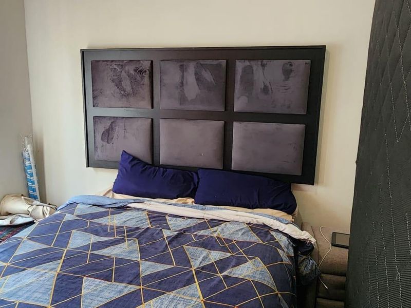 A bedroom featuring a wall-mounted headboard.