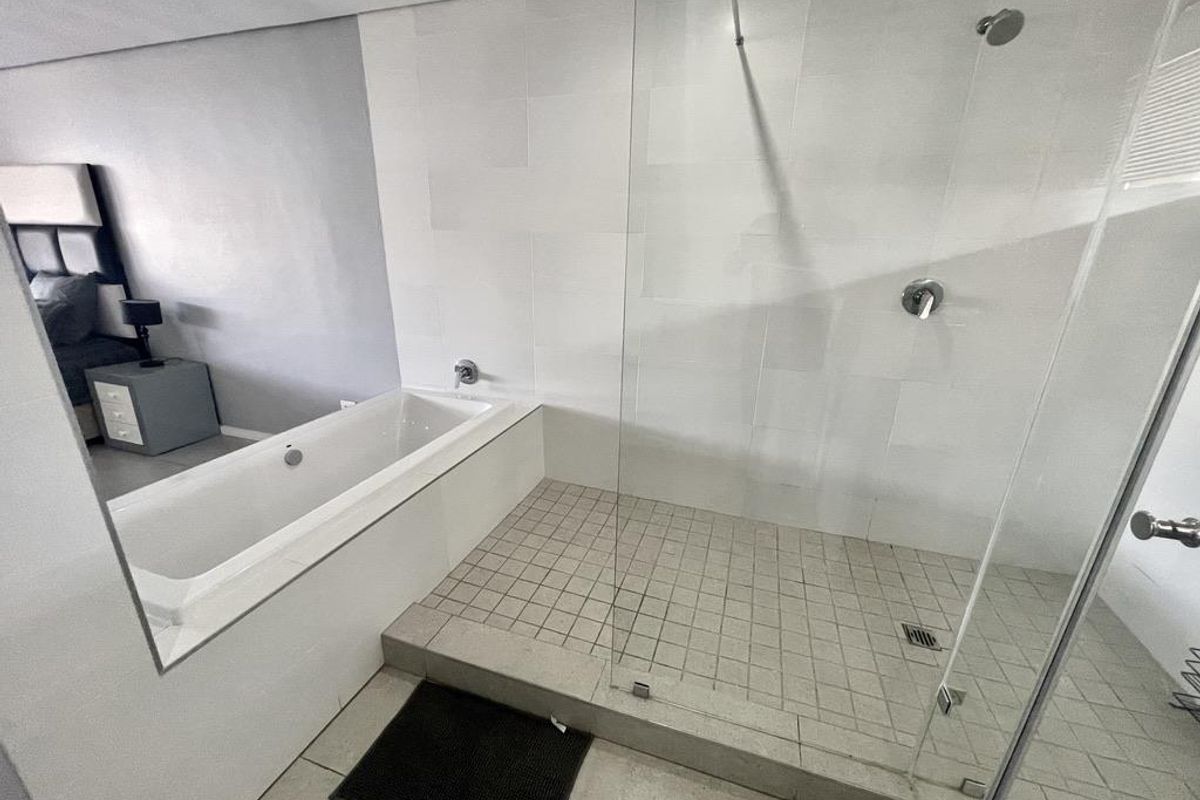 Modern bathroom featuring a built-in bathtub and a separate walk-in shower with a glass enclosure and tiled flooring.