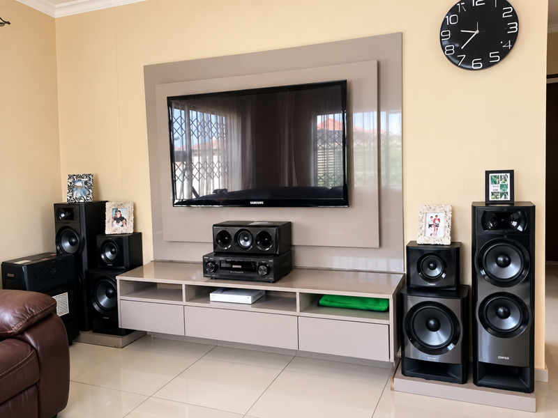 A well-maintained living room featuring a modern built-in media console, tiled flooring, and neutral wall finishes.