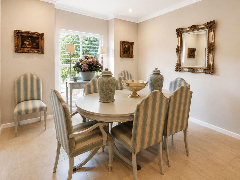 A well-maintained dining room featuring neutral tiled flooring, crown molding, recessed lighting, and a window with fitted shutters.