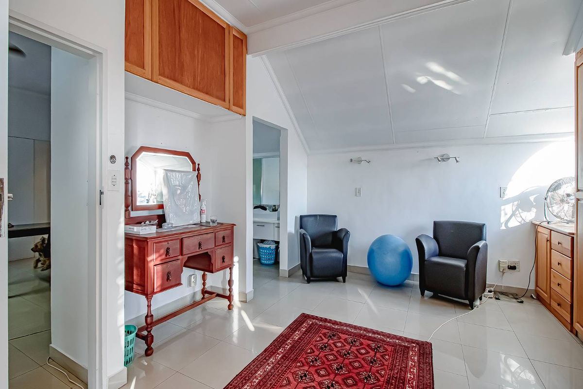 A multi-purpose bedroom space featuring tiled flooring, built-in cabinetry, and an en-suite bathroom access point.