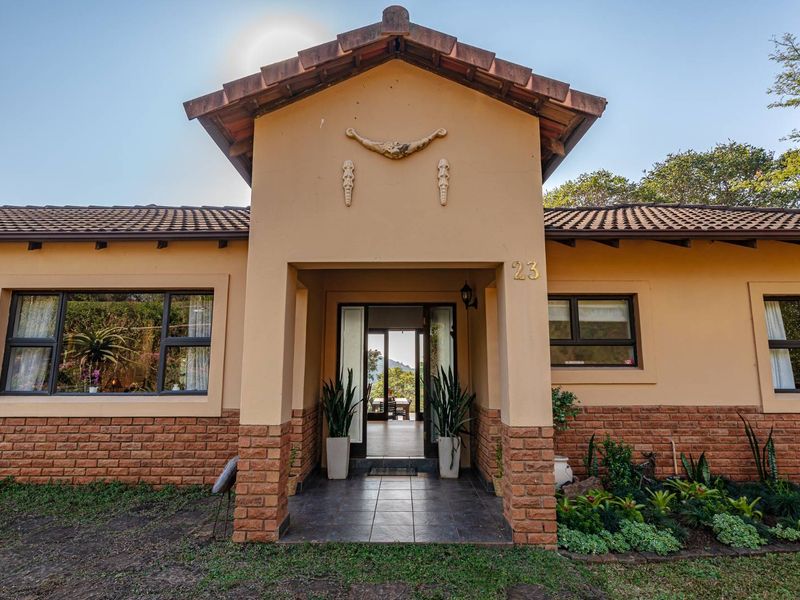 Front elevation of a townhouse featuring a tiled roof, brick and plaster facade, and a covered entrance porch with tiled flooring.