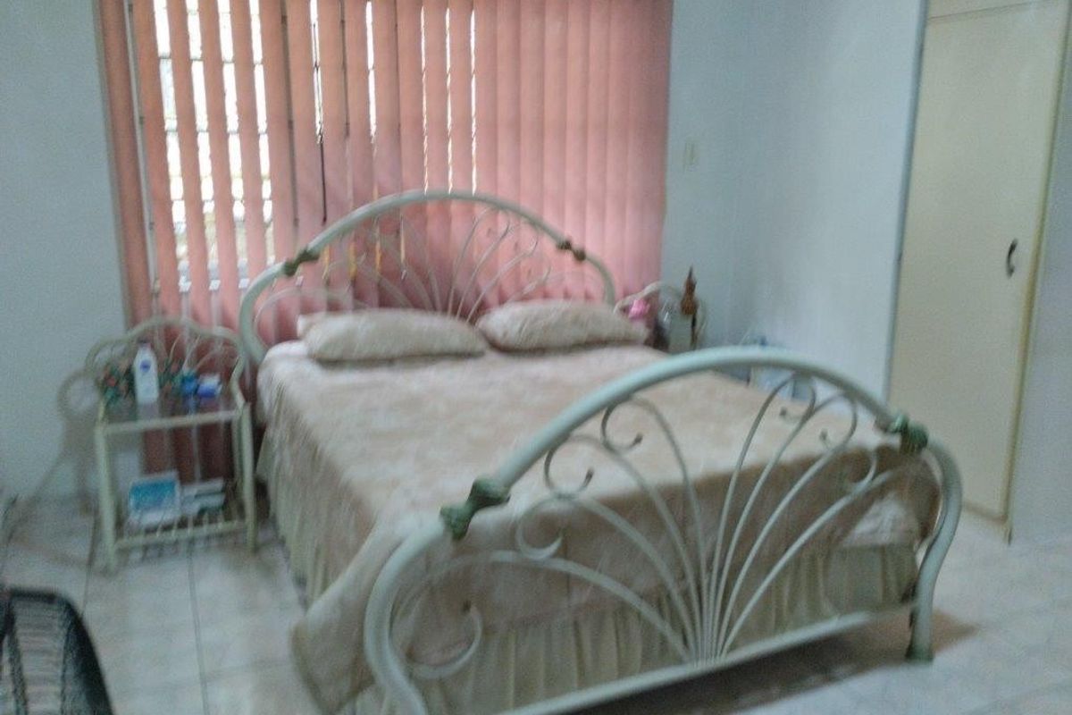 A bedroom featuring tiled flooring, a built-in wardrobe, and vertical blinds covering the window.