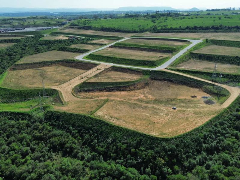 Aerial view of a large industrial development site featuring terraced land plots and established paved access roads.