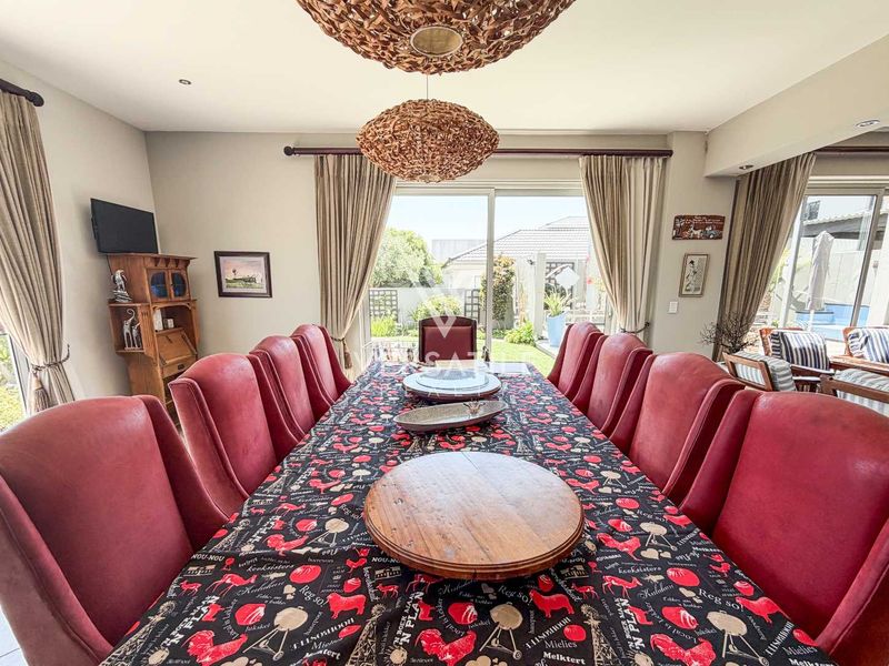 Spacious dining room featuring large sliding glass doors that provide natural light and direct access to the outdoor patio area.