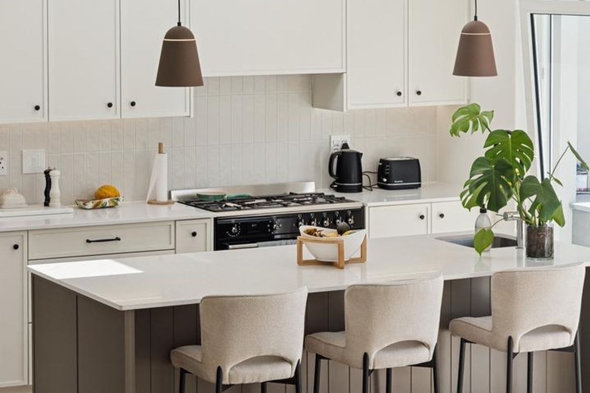 Modern kitchen featuring a central island with stone countertops, integrated cabinetry, a gas cooktop, and stylish pendant lighting.