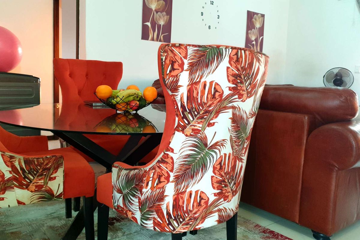 A view of a living area featuring a dining set and leather sofa, with standard residential finishes.