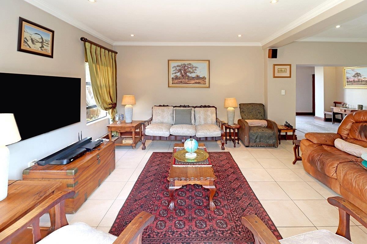 A spacious living room featuring neutral walls, tiled flooring, and recessed downlighting, offering a comfortable and well-maintained area for relaxation.