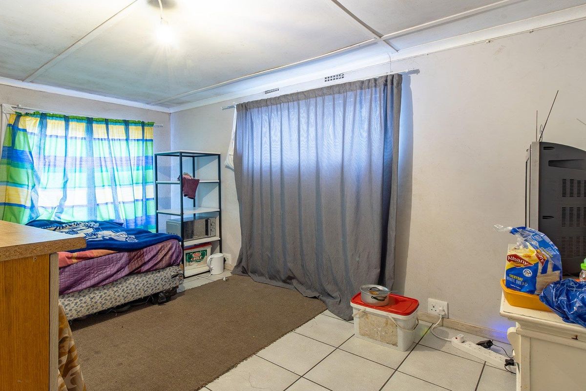 A bedroom featuring tiled flooring and ceiling panels, requiring cosmetic updates to improve the overall condition and appeal of the space.
