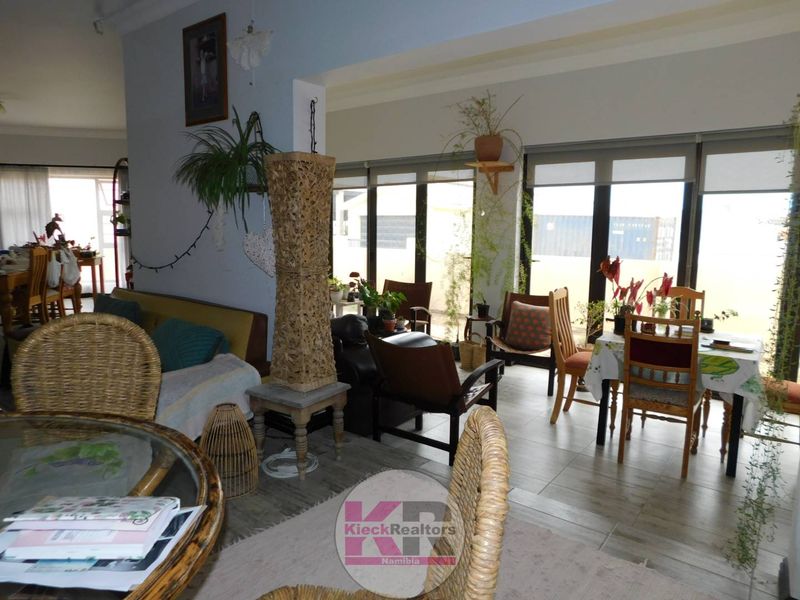 Spacious open-plan living and dining area featuring large glass sliding doors that provide ample natural light and access to the exterior.