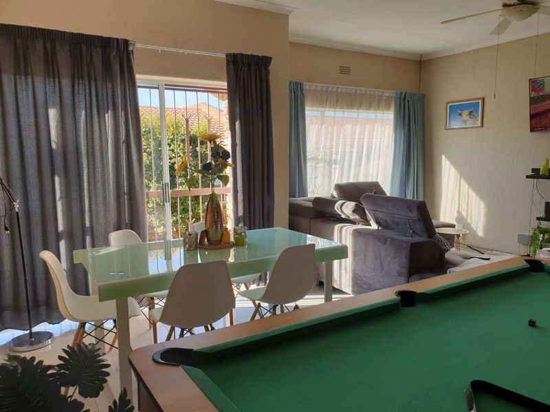 Spacious open-plan living and dining area featuring large sliding doors that provide natural light and access to the outdoor space.