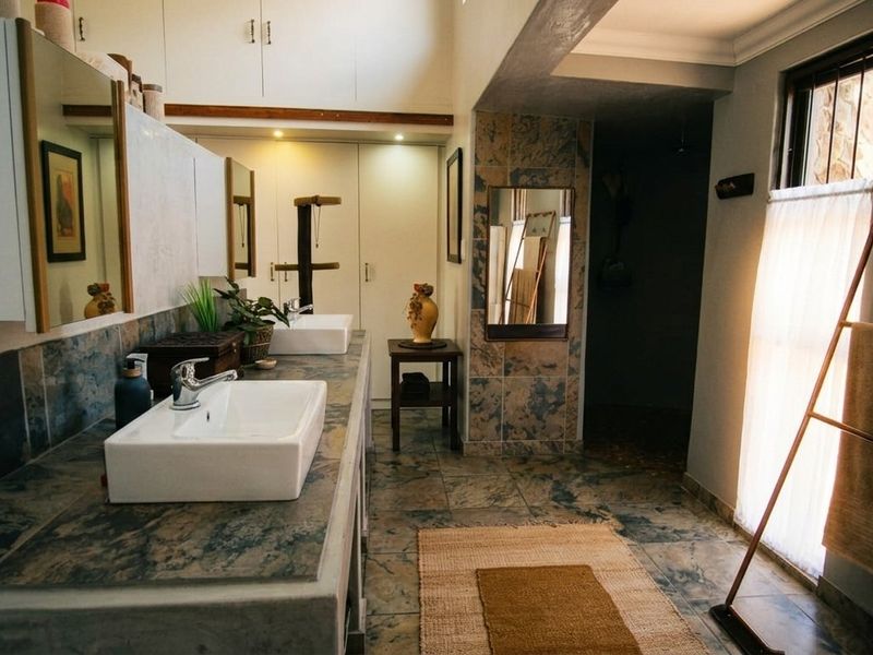 Spacious bathroom featuring a double vanity with vessel sinks, extensive built-in cabinetry, and decorative tiled finishes throughout.