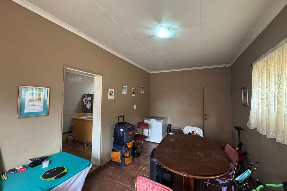 A multi-purpose living area featuring tiled flooring and direct access to an adjacent kitchen space.